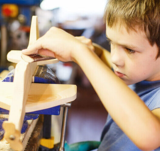 Child making wooden airplane